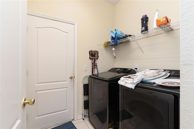 clothes washing area featuring light tile patterned flooring and washing machine and dryer