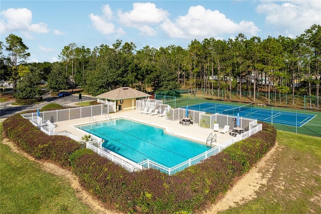 view of swimming pool with a patio and tennis court