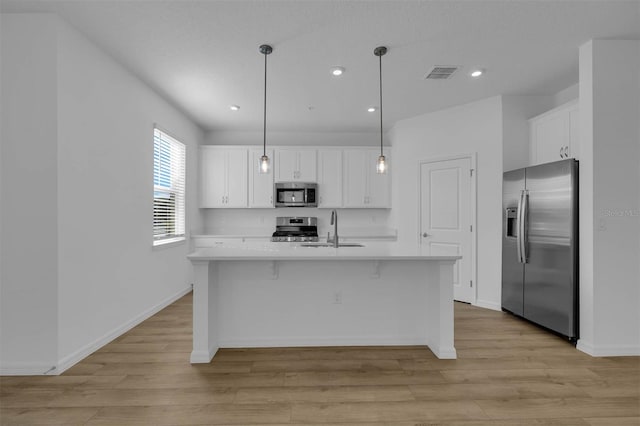 kitchen featuring white cabinetry, appliances with stainless steel finishes, sink, and pendant lighting