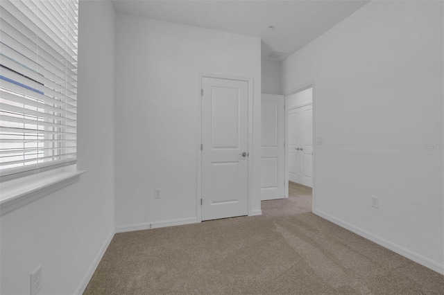 unfurnished bedroom featuring light colored carpet