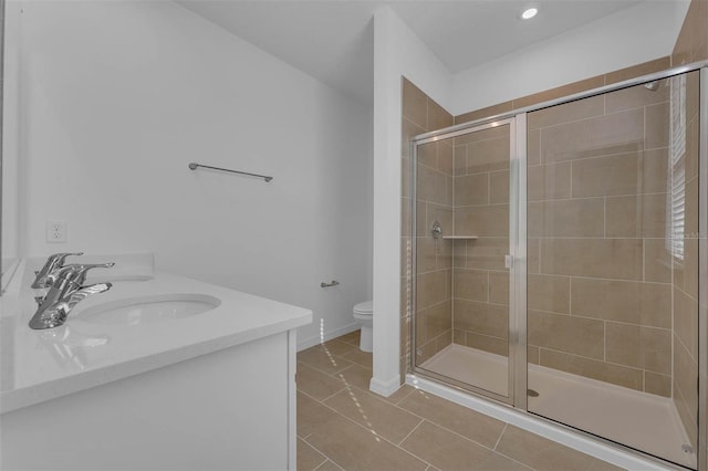 bathroom with vanity, toilet, a shower with shower door, and tile patterned flooring