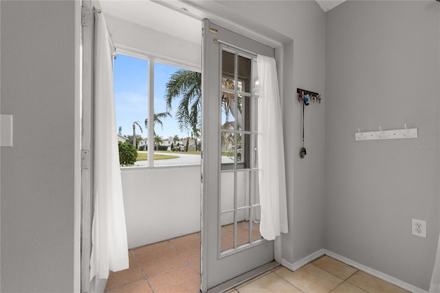 doorway to outside with light tile patterned flooring