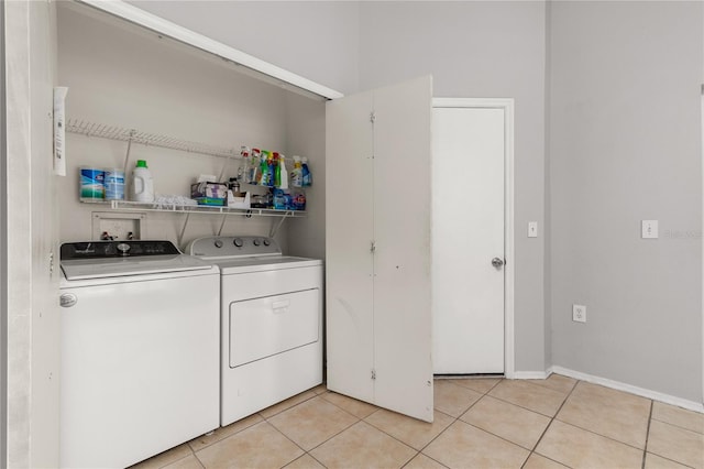 laundry area featuring washing machine and dryer and light tile patterned floors