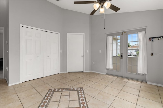 unfurnished bedroom with french doors, access to exterior, ceiling fan, high vaulted ceiling, and light tile patterned floors