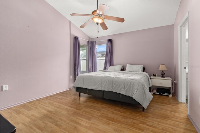 bedroom featuring light hardwood / wood-style floors, ceiling fan, and vaulted ceiling