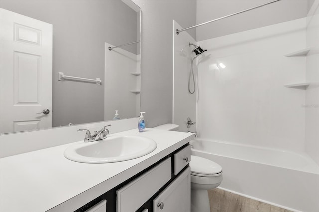 full bathroom with  shower combination, vanity, hardwood / wood-style floors, and toilet