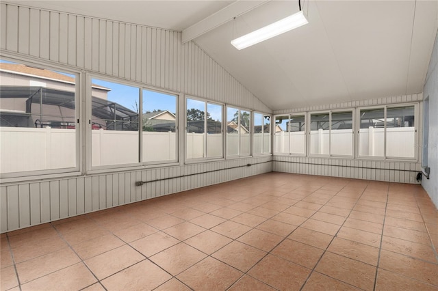 unfurnished sunroom with vaulted ceiling with beams