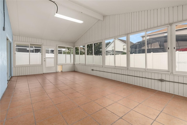 unfurnished sunroom with lofted ceiling with beams and plenty of natural light