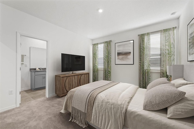 carpeted bedroom with multiple windows and ensuite bath