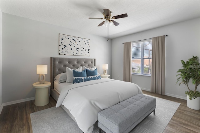 bedroom with dark wood-type flooring, ceiling fan, and a textured ceiling
