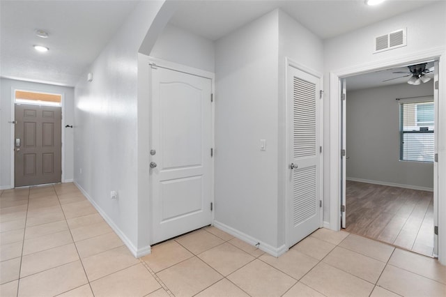 foyer featuring ceiling fan and light tile patterned floors