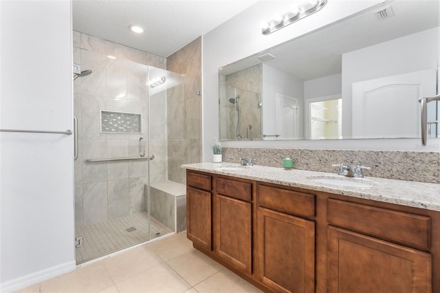 bathroom with tile patterned flooring, vanity, and a shower with door