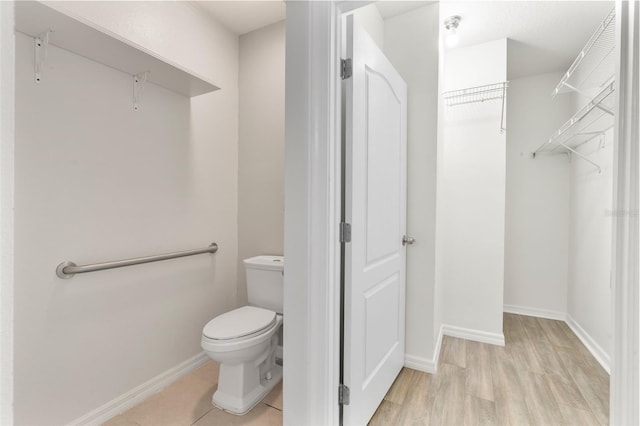 bathroom with hardwood / wood-style flooring and toilet