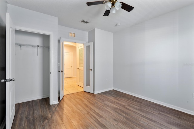 unfurnished bedroom with ceiling fan, dark hardwood / wood-style floors, and a closet