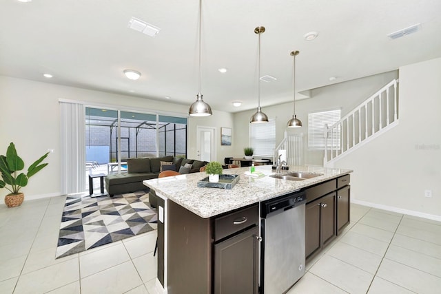 kitchen featuring hanging light fixtures, a kitchen island with sink, stainless steel dishwasher, dark brown cabinetry, and sink