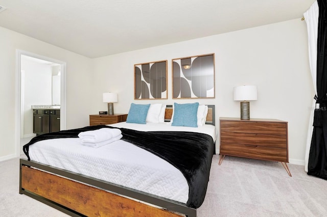 bedroom featuring light carpet and connected bathroom