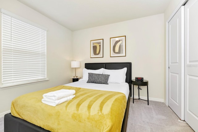 carpeted bedroom featuring a closet and multiple windows