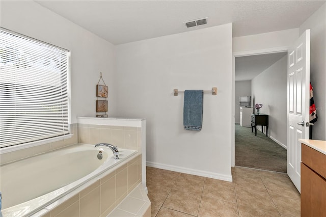 bathroom with baseboards, visible vents, tile patterned flooring, vanity, and a bath