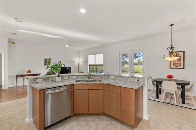 kitchen with a sink, an island with sink, stainless steel dishwasher, and light stone countertops