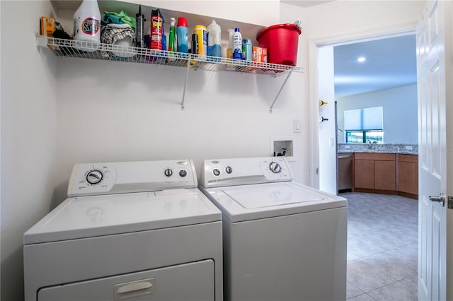 washroom featuring laundry area, separate washer and dryer, and a sink