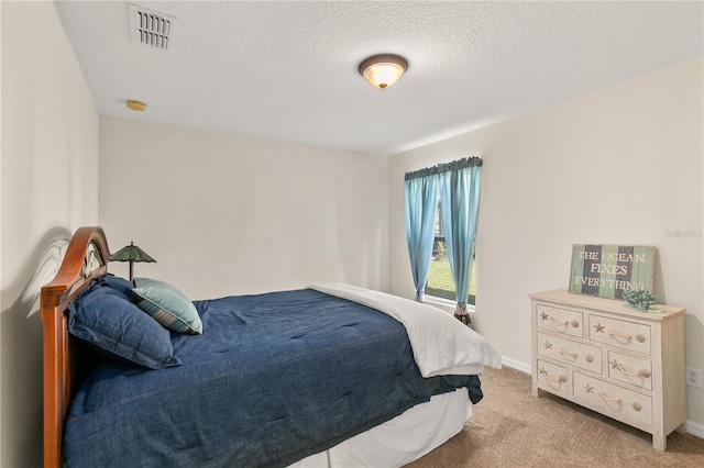 bedroom with light colored carpet, visible vents, a textured ceiling, and baseboards