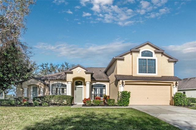 view of front facade featuring a garage, driveway, a front lawn, and stucco siding