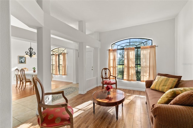 living area with light wood finished floors, baseboards, and a chandelier