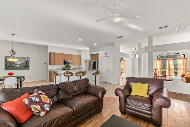 living area featuring baseboards, recessed lighting, visible vents, and light wood-style floors