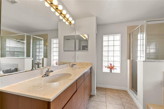 bathroom featuring double vanity, visible vents, tile patterned flooring, a textured ceiling, and a sink