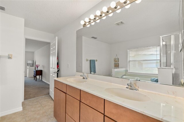 bathroom featuring tile patterned flooring, a sink, and visible vents