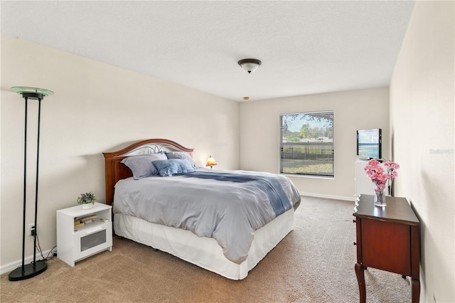 bedroom featuring carpet, baseboards, and a textured ceiling