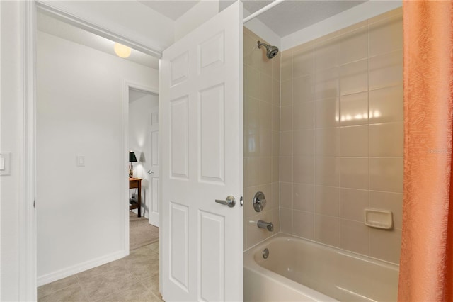 full bathroom featuring tile patterned flooring, washtub / shower combination, and baseboards