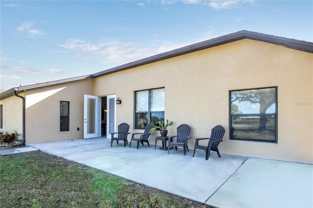 back of house with a patio and stucco siding