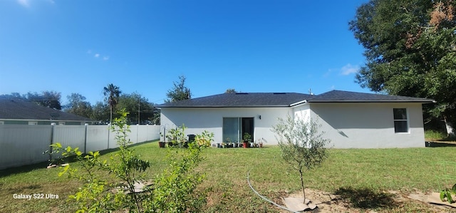 rear view of house featuring a yard