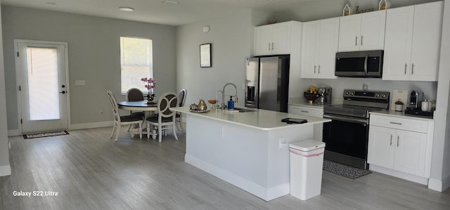 6748 Cherry Rd, Ocala, FL 34472 - kitchen with appliances with stainless steel finishes, a sink, white cabinetry, a center island with sink, and light wood-type flooring
