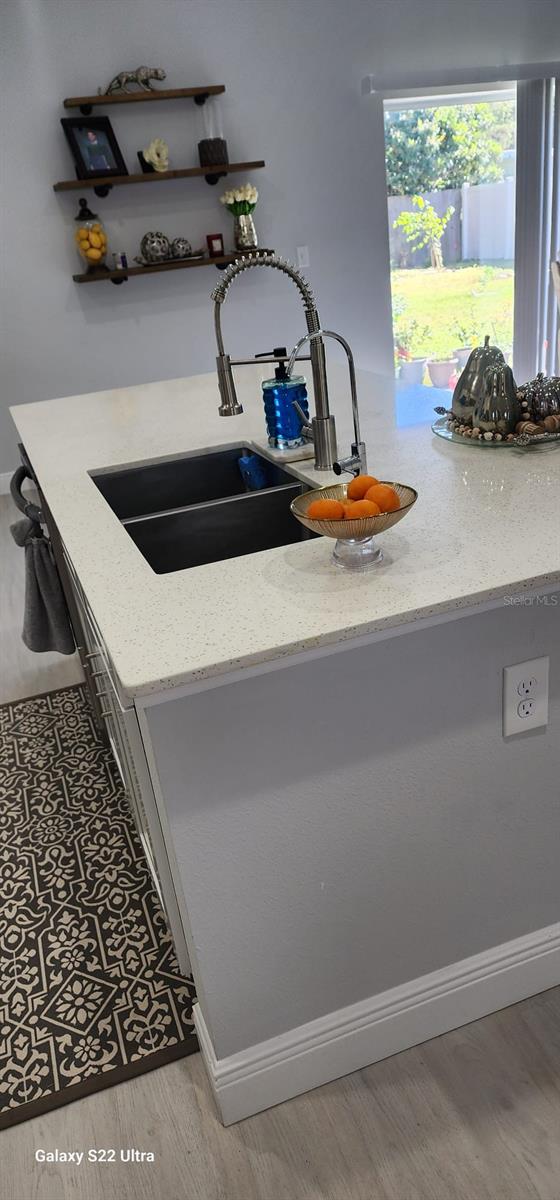 6748 Cherry Rd, Ocala, FL 34472 - details featuring a sink, light stone countertops, and wood finished floors