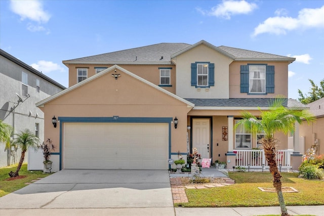 front of property featuring a porch, a front lawn, and a garage