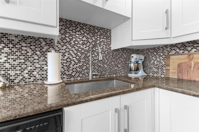 kitchen with sink, dishwasher, white cabinets, decorative backsplash, and dark stone counters