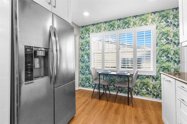 kitchen featuring white cabinetry, stainless steel fridge with ice dispenser, and light wood-type flooring