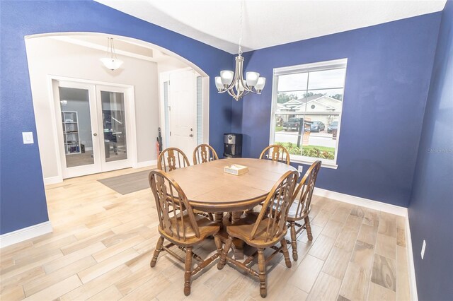 dining space with light hardwood / wood-style flooring and a chandelier