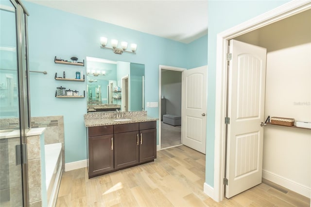 bathroom featuring vanity, hardwood / wood-style flooring, and independent shower and bath