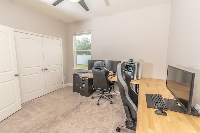 carpeted home office featuring ceiling fan