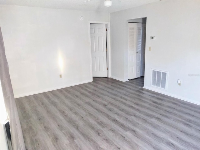 empty room with ceiling fan, a textured ceiling, and hardwood / wood-style floors