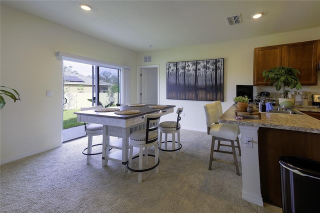 carpeted dining area with sink