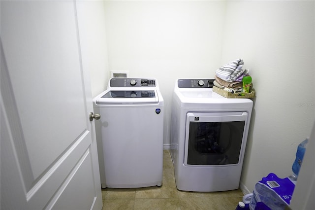 clothes washing area with washer and dryer and light tile patterned floors