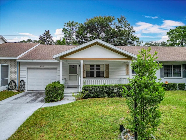 ranch-style house featuring covered porch, a front yard, and a garage