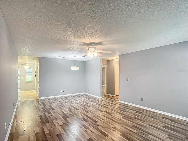 spare room featuring a textured ceiling, hardwood / wood-style flooring, and ceiling fan