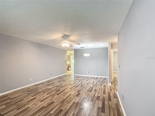 spare room with ceiling fan, a textured ceiling, and hardwood / wood-style floors