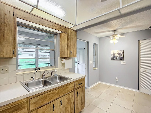 kitchen featuring sink, ceiling fan, backsplash, and light tile patterned floors