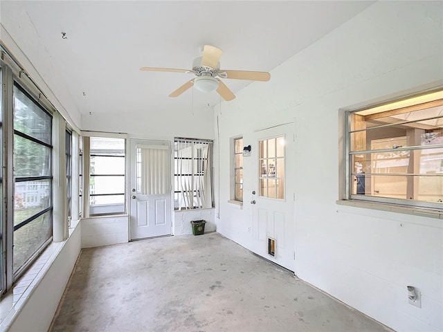 unfurnished sunroom featuring ceiling fan